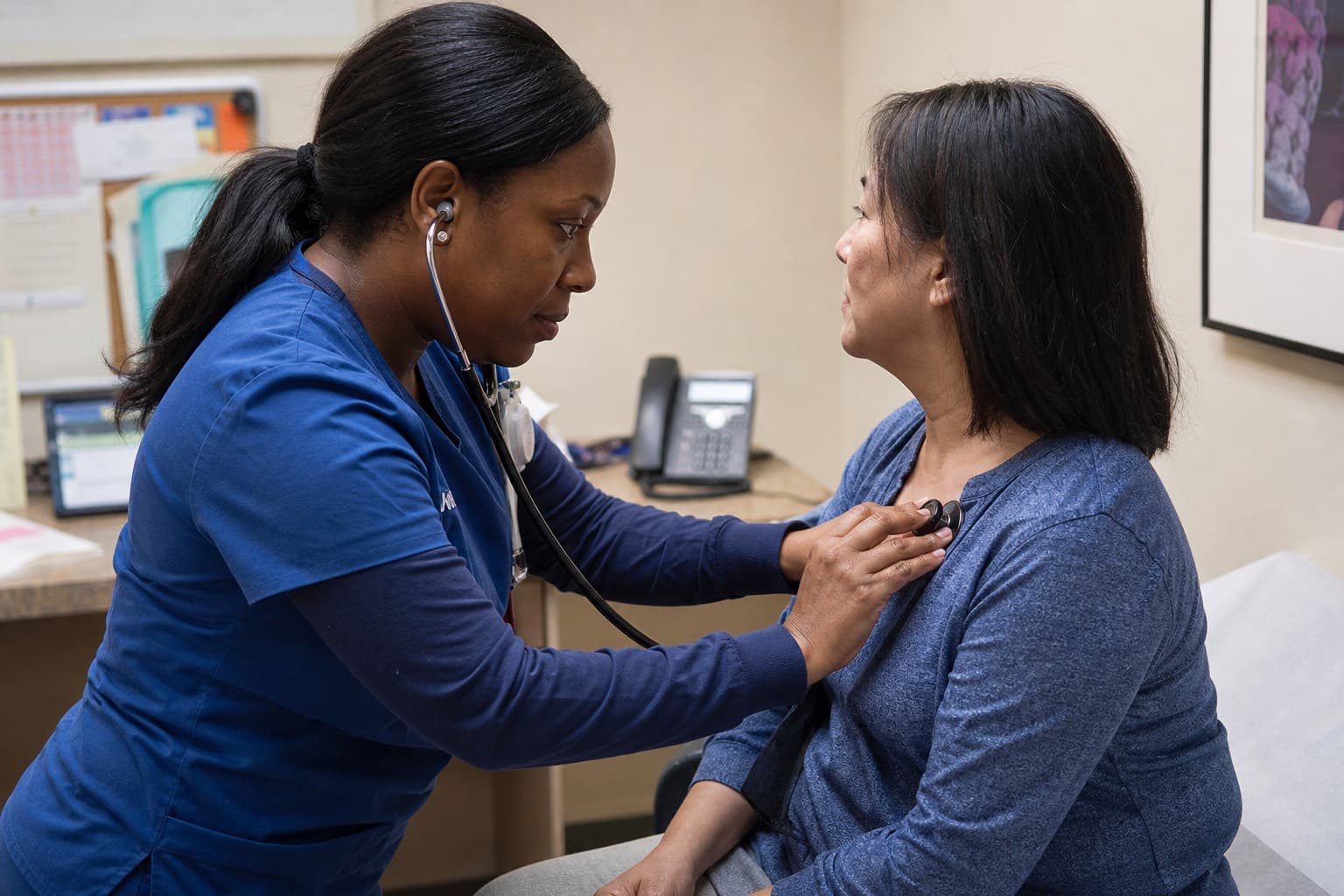 Clinician checking a patient’s vitals in an exam room